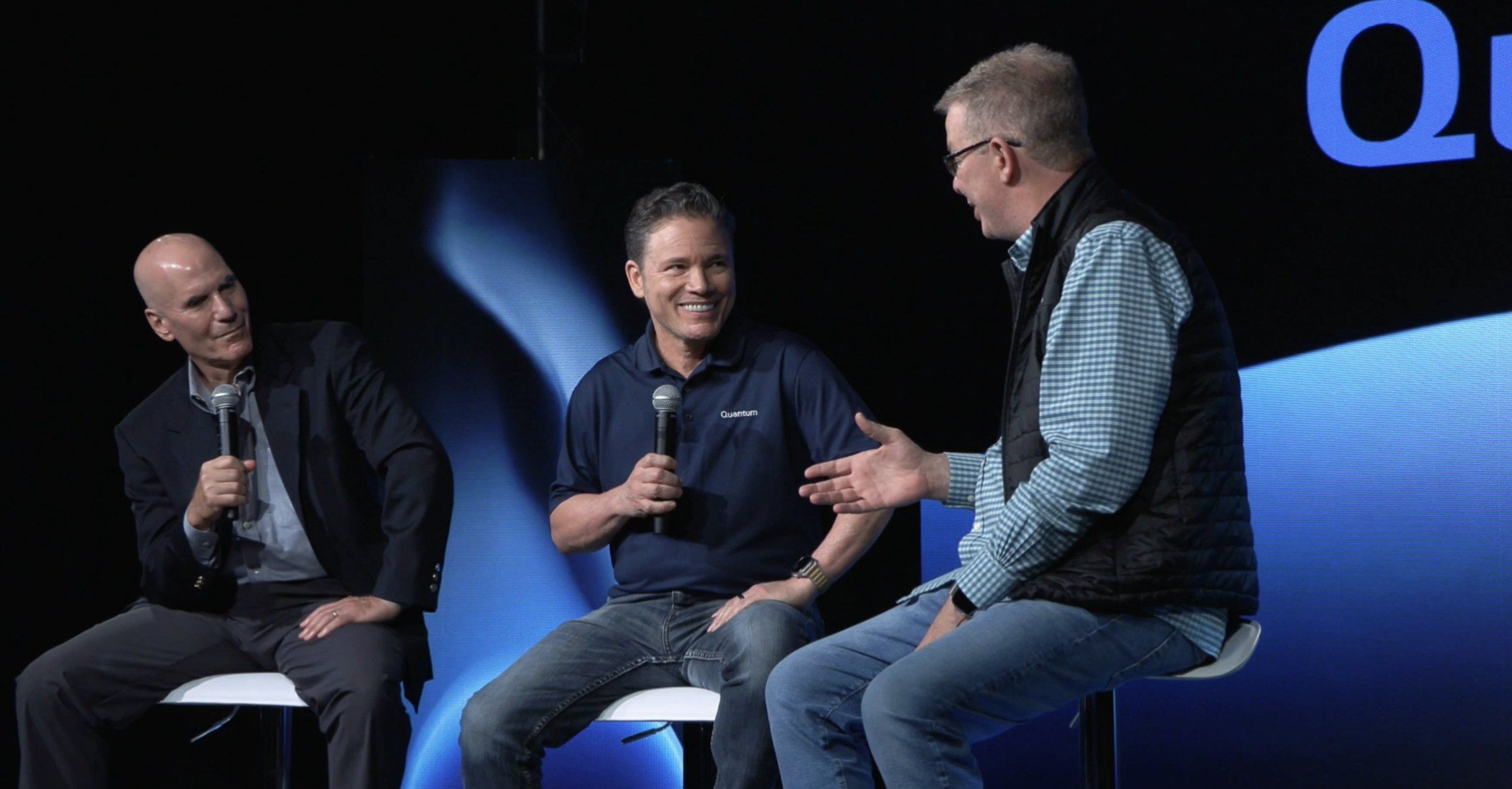 Skip Levens (center), Marc Staimer of Dragon Slayer, and Greg Knieriemen of Quantum at launch of Quantum ADM: three speakers on stools with microphones, in front of a blue backdrop.